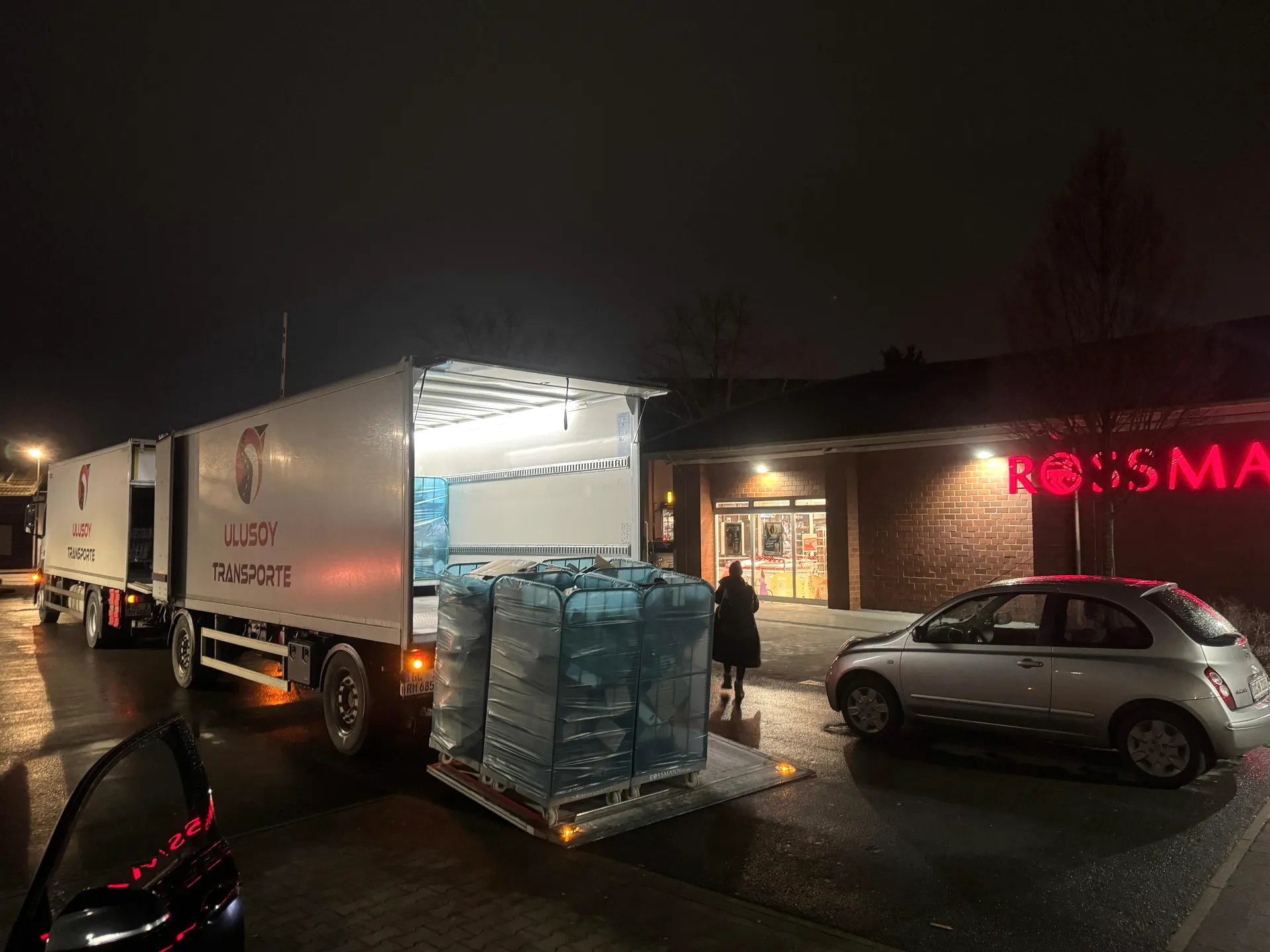 Nächtliche Zustellung: Ulusoy Motorwagen mit Rollcontainern auf der Ladebordwand vor einer Filiale